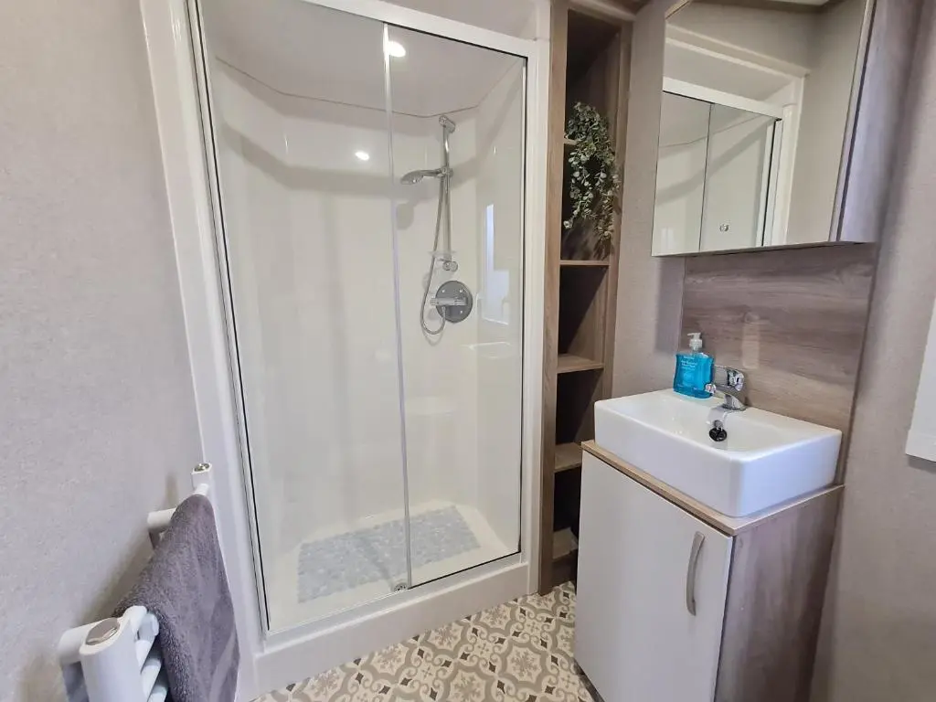 a bathroom with a shower and a sink at Silversands - Private Caravan Let in Lossiemouth