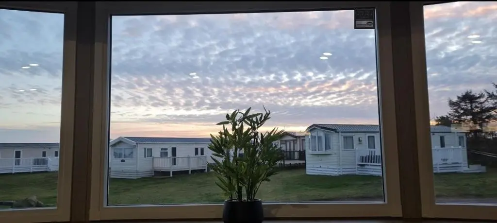 a window with a view of a group of houses at Silversands - Private Caravan Let in Lossiemouth