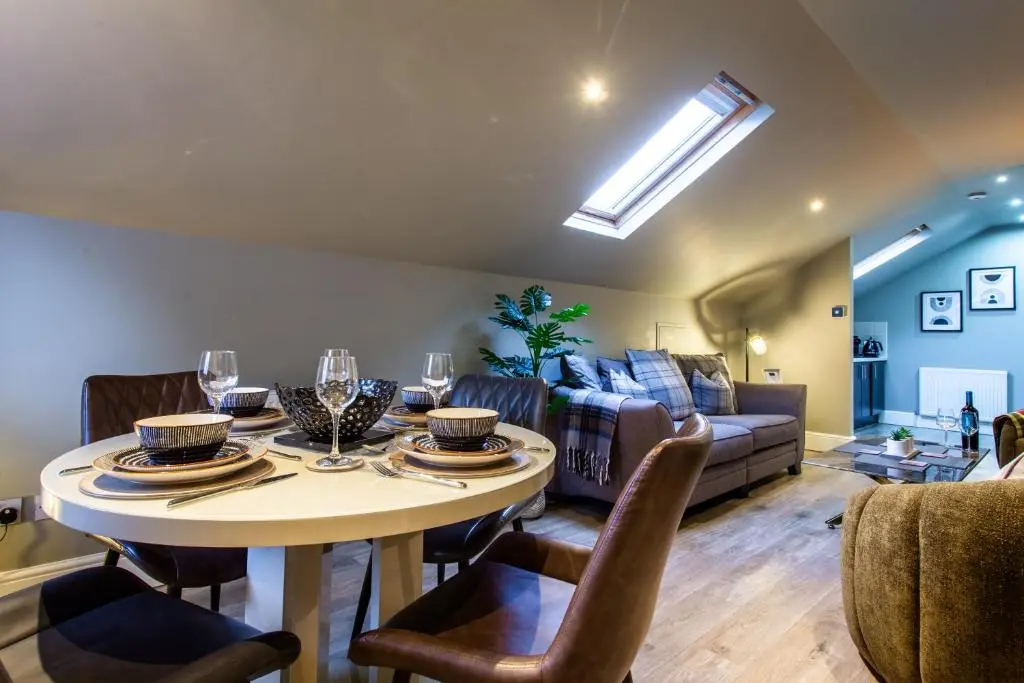 a living room with a table and a couch at 17 at the Bell Tower in Inverness