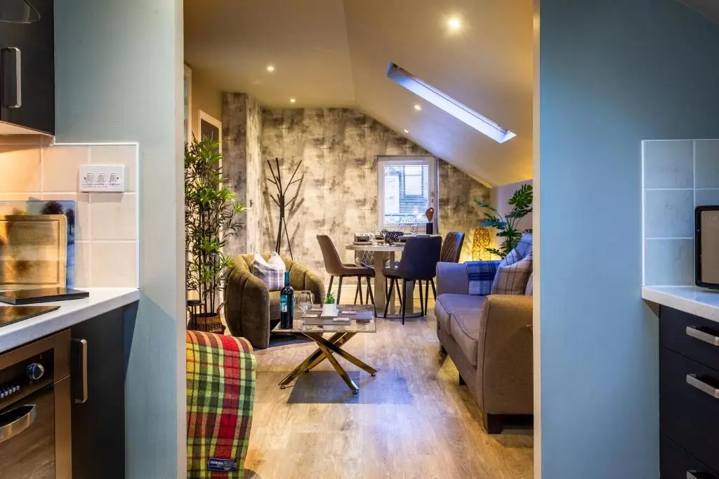 a kitchen and a living room with a table at 17 at the Bell Tower in Inverness