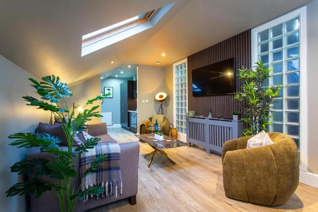 a living room with a couch and a tv at 17 at the Bell Tower in Inverness