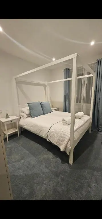 a bedroom with a white bed with a canopy at Inverness City Centre Modern Apartment in Dalneigh