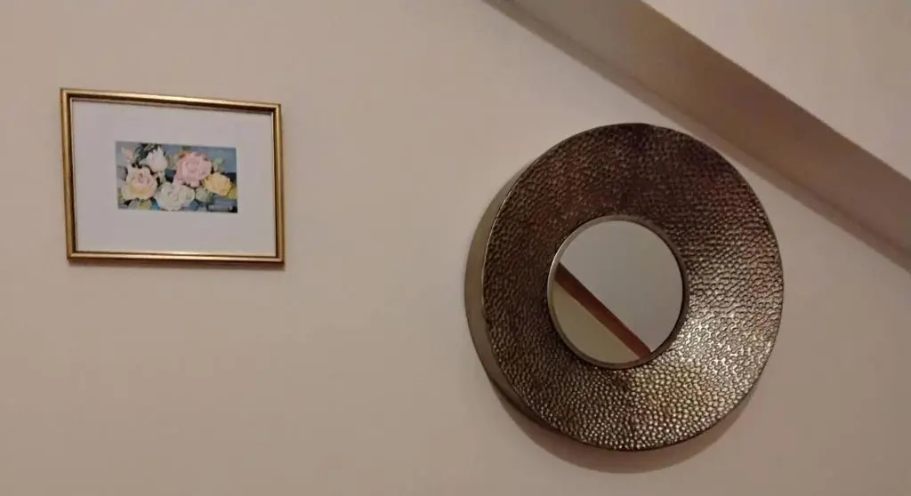 a mirror on a wall next to a picture at Turfhill House in New Deer