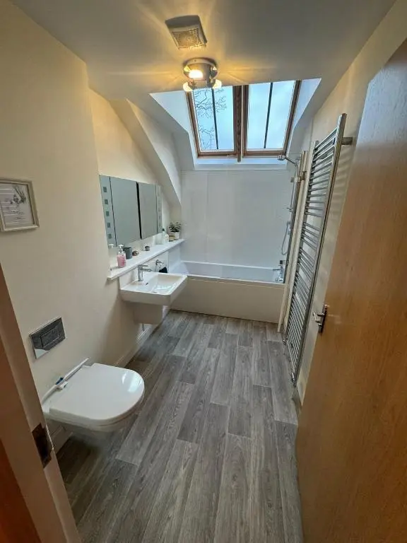 a bathroom with a toilet and a sink and a window at Turfhill House in New Deer