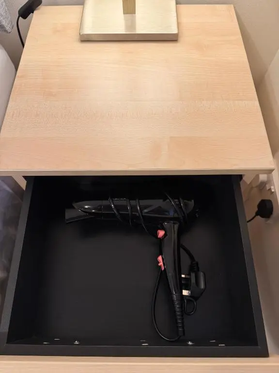 a drawer under a wooden table with a black cord at Comfortable double room with own bathroom in Inshes