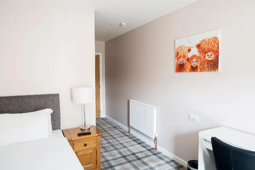 a bedroom with a bed and a painting on the wall at Poseidon's in Lossiemouth