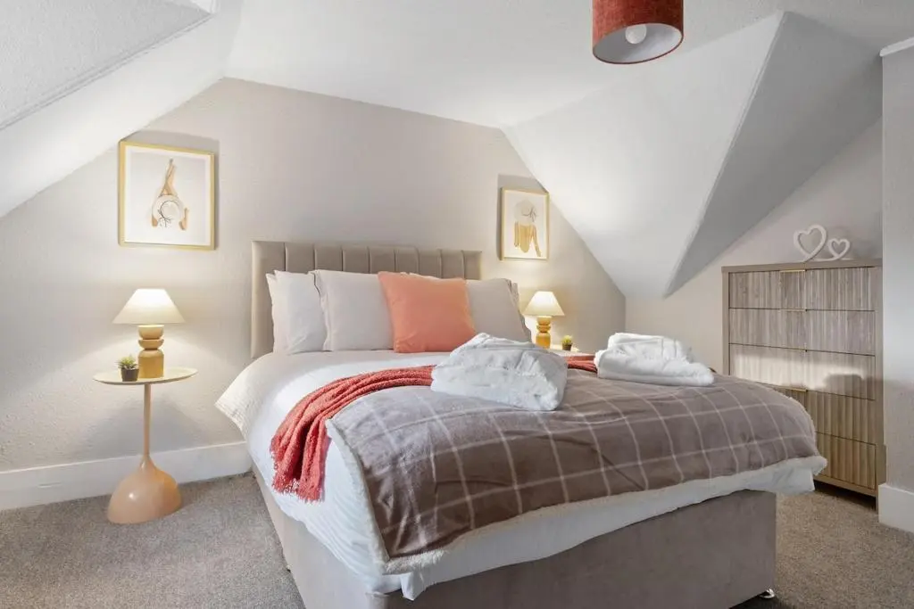 a bedroom with a large bed in a attic at Leo Apartment - 4 Bedroom Flat in Nairn in Nairn