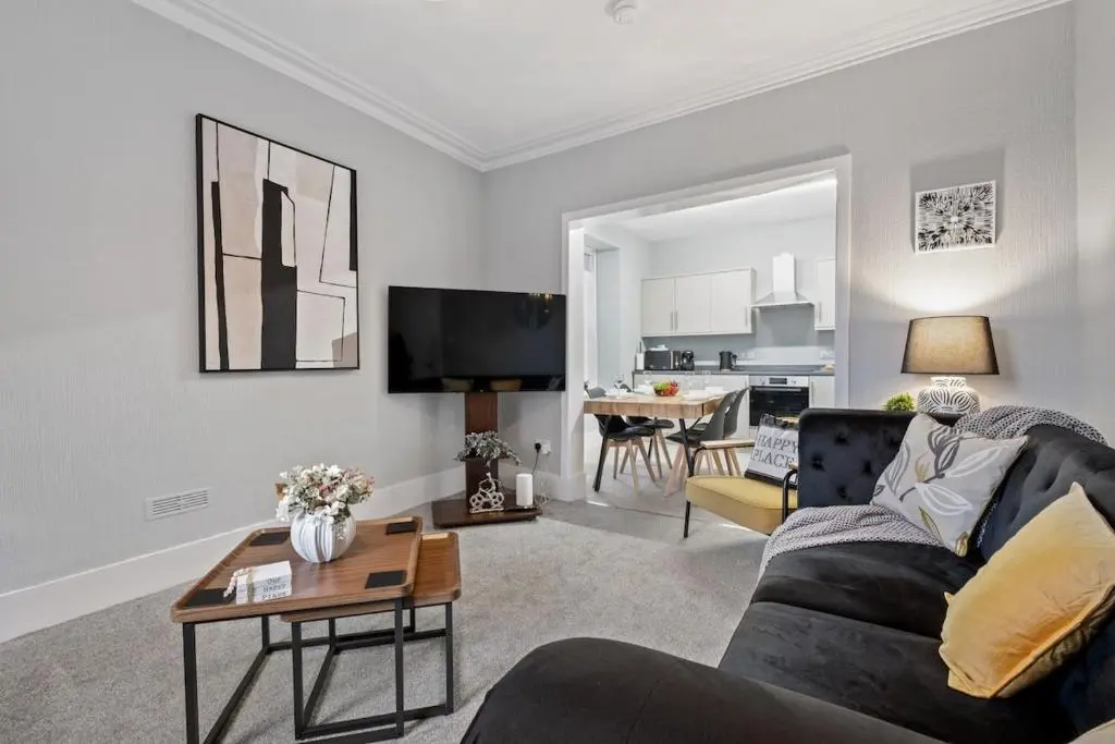 a living room with a couch and a table at Leo Apartment - 4 Bedroom Flat in Nairn in Nairn