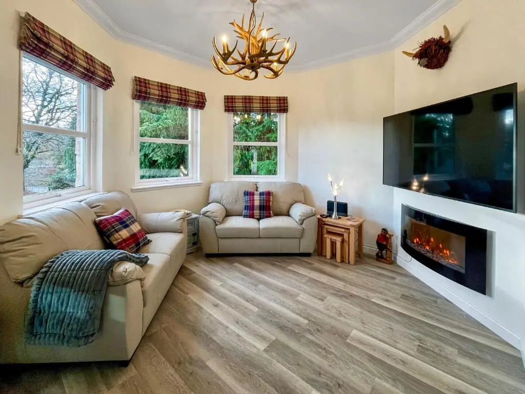 a living room with two couches and a fireplace at Dee View Apartment in Banchory