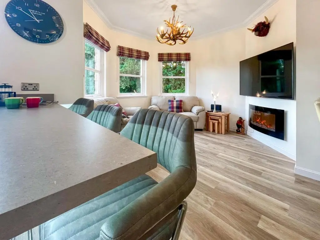 a living room with a table and a couch at Dee View Apartment in Banchory