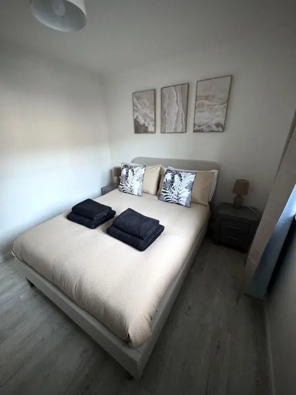 a bedroom with a large white bed with two pillows at Culduthel Court Apartment in Inshes