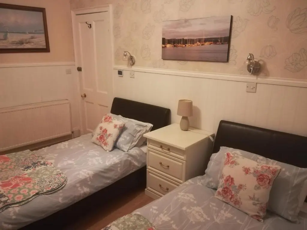 a bedroom with two beds and a night stand at Atherstone B&B in Inverness