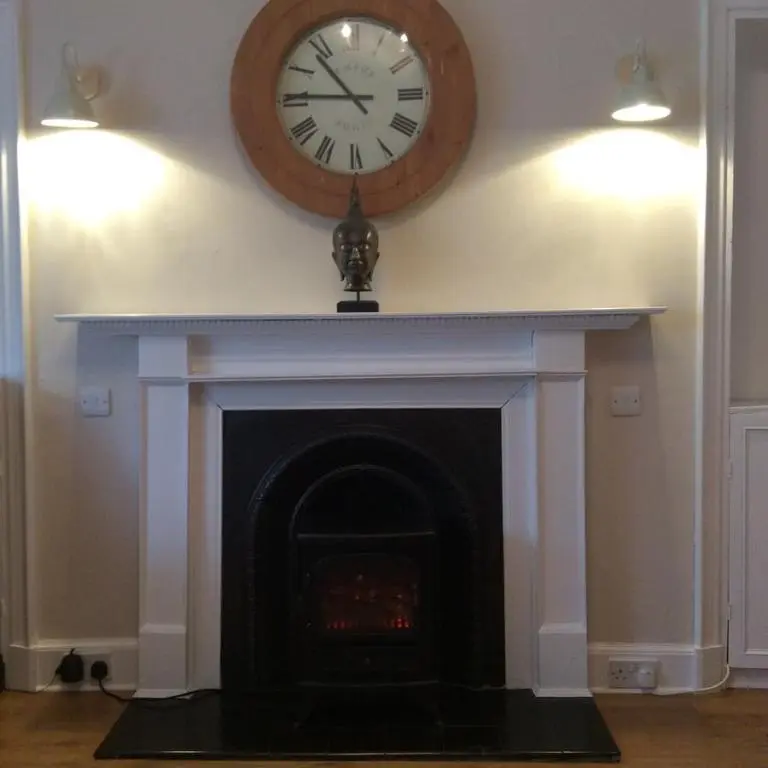 a clock on the wall above a fireplace at Atherstone B&B in Inverness