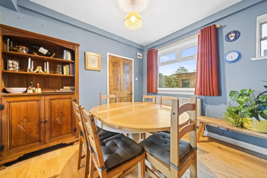 a dining room with a wooden table and chairs at Beinn View 3 Bedroom House - Sea View - Ardersier in Ardersier
