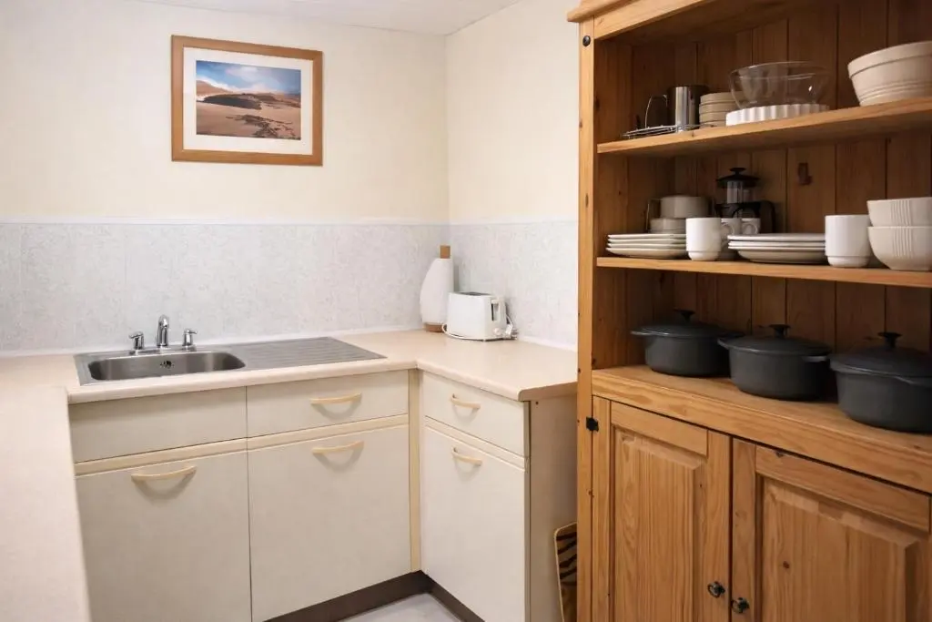 a kitchen with a sink and wooden cabinets at Overscaig House - The Annexe in Lairg