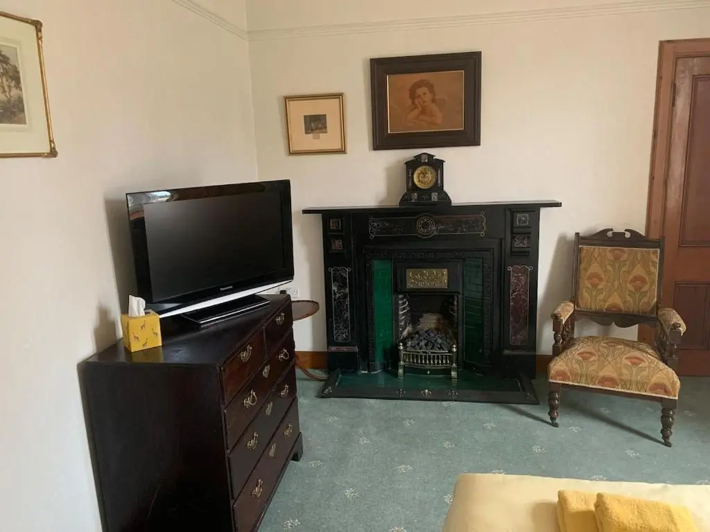 a living room with a television and a fireplace at Glenerne 3 bedroom Cottage in Elgin