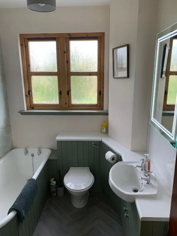 a bathroom with a sink and a toilet and a bath tub at Glenerne 3 bedroom Cottage in Elgin