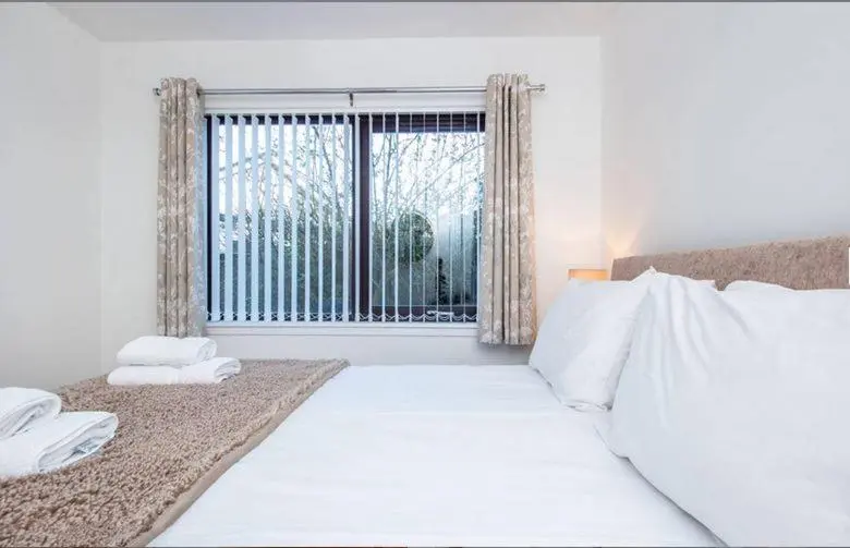 a bedroom with a large white bed and a window at 2 Bedroom Macewen Drive in Inverness