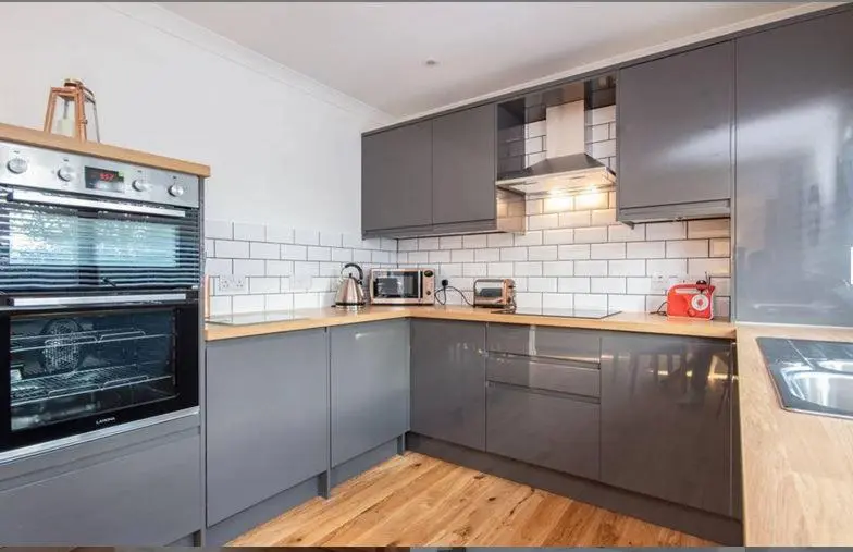 a kitchen with stainless steel appliances and wooden floors at 2 Bedroom Macewen Drive in Inverness