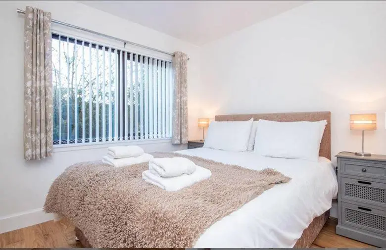 a bedroom with a bed with two towels on it at 2 Bedroom Macewen Drive in Inverness