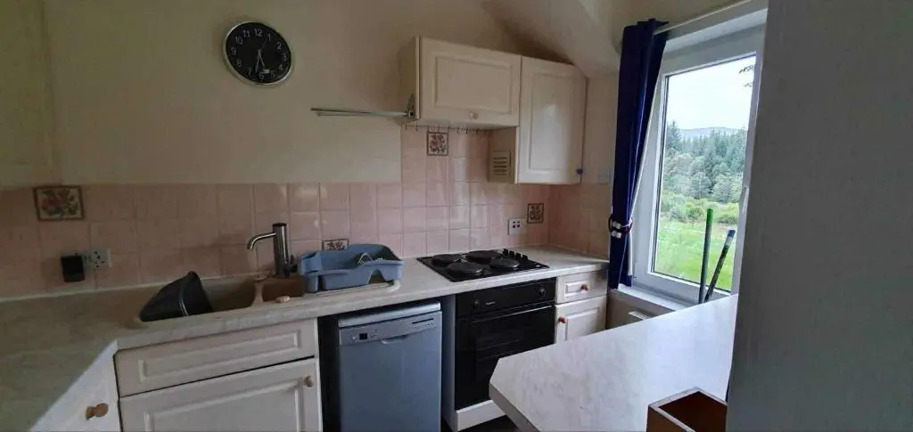 a kitchen with a sink and a stove and a window at River View in Garve