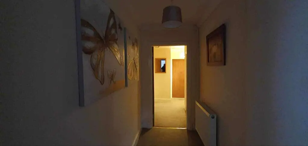 a hallway with a hallway leading into a room with paintings at River View in Garve