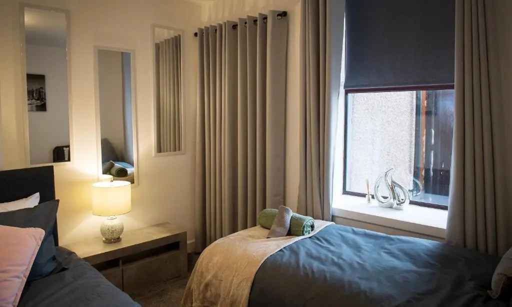 a hotel room with a bed and a window at Rook View, Modern Coastal Retreat with Free Parking in Buckie