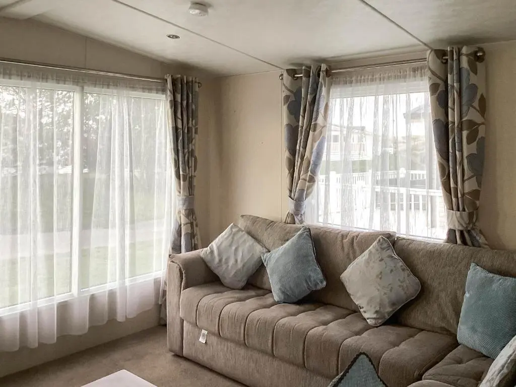 a living room with a couch and two windows at A Stone's Throw in Lossiemouth