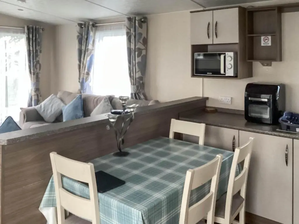 a kitchen and dining room with a table and chairs at A Stone's Throw in Lossiemouth