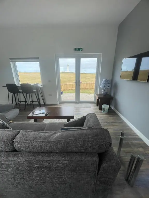 a living room with a couch and a table at 1 Lighthouse View in Lossiemouth