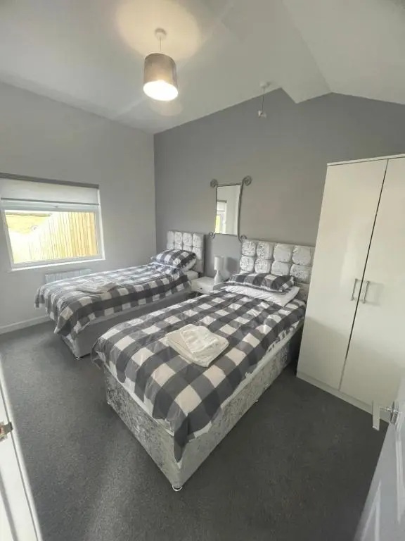 a bedroom with two beds and a cabinet at 1 Lighthouse View in Lossiemouth