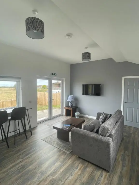 a living room with a couch and a table at 1 Lighthouse View in Lossiemouth