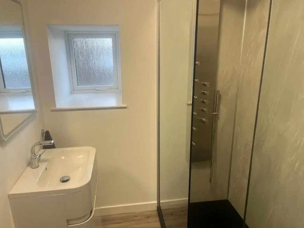 a white bathroom with a sink and a shower at Newly Renovated Luxuary Flat overlooking Wick Bay in Wick