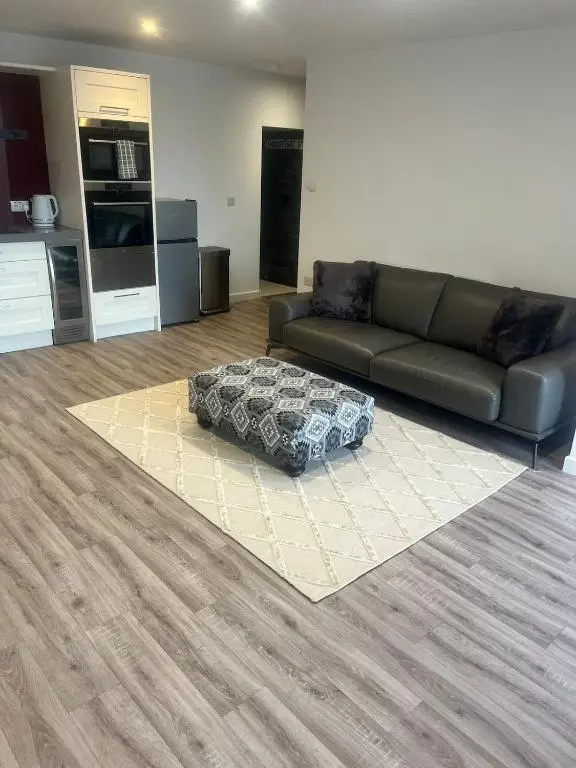 a living room with a couch and a kitchen at Newly Renovated Luxuary Flat overlooking Wick Bay in Wick