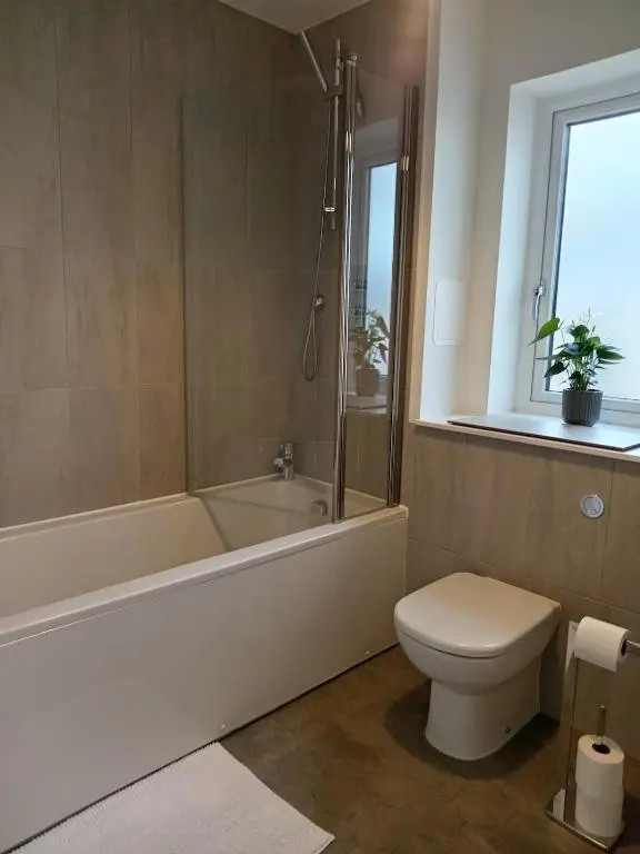a bathroom with a tub and a toilet and a sink at Modern 4 Bed Highland Home in Culloden
