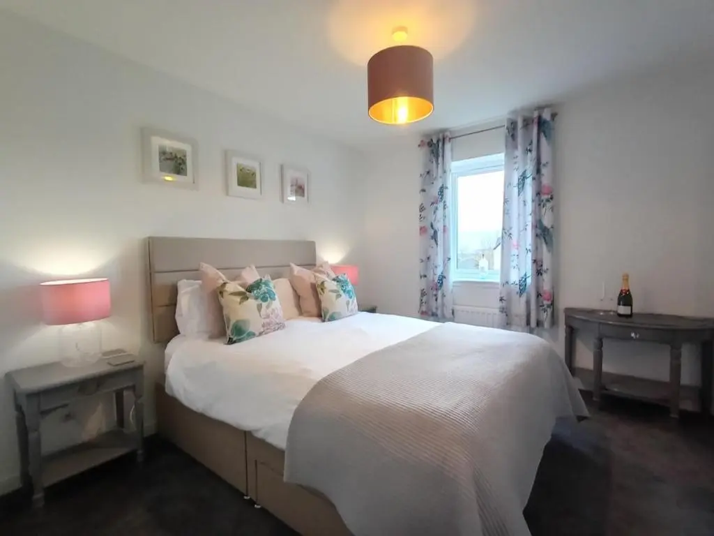 a bedroom with a white bed with pillows and a window at Modern 4 Bed Highland Home in Culloden