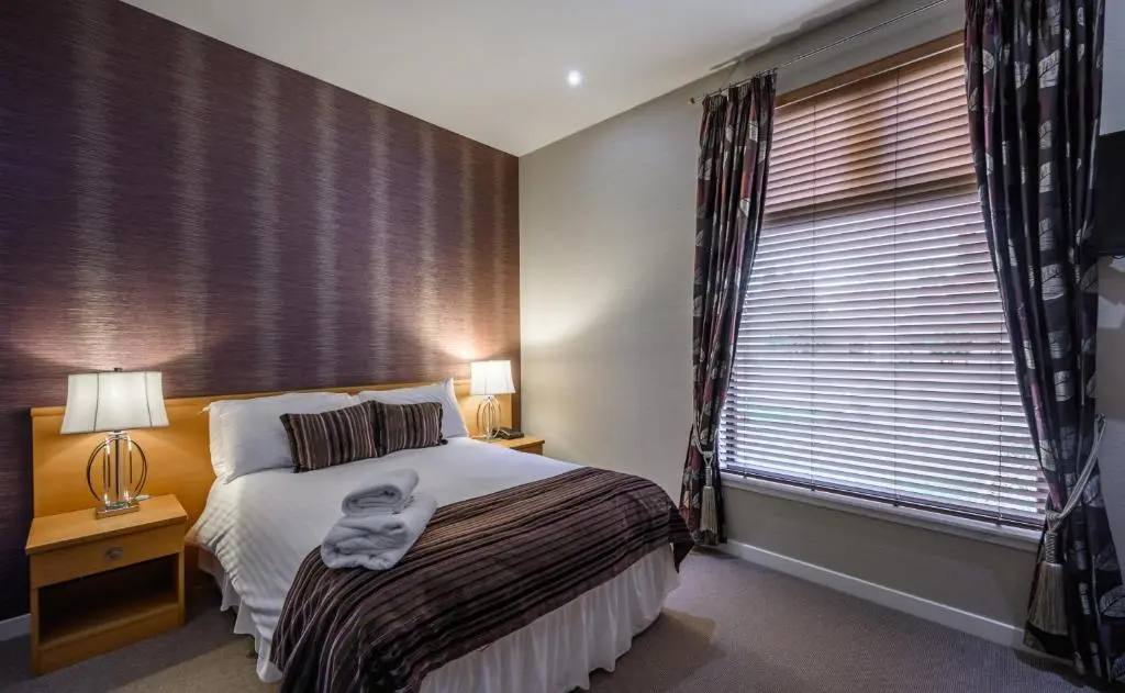 a bedroom with a bed and a large window at The Dunavon in Dyce
