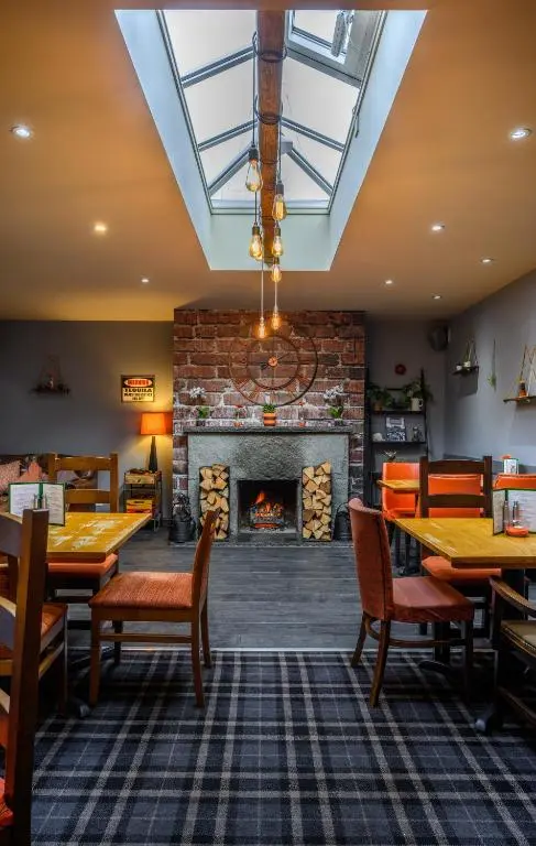 a dining room with tables and a fireplace at The Dunavon in Dyce