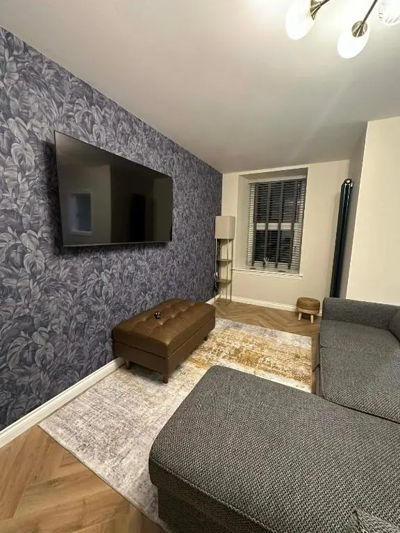 a living room with a couch and a flat screen tv at Modern central apartment in Wick