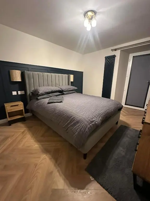 a bedroom with a large bed in a room at Modern central apartment in Wick