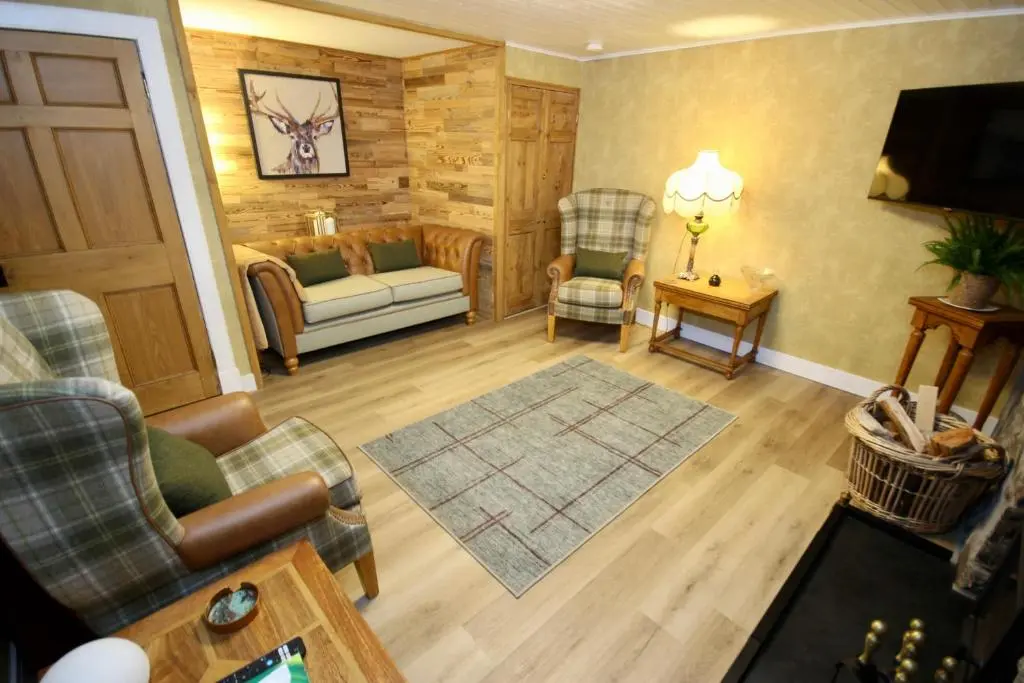 a living room with a couch and chairs and a television at Serenity by the Sea in Buckie