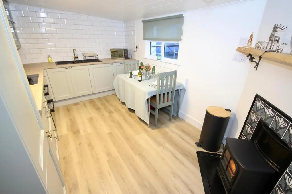 a kitchen with a dining room table and a kitchen with a counter at Serenity by the Sea in Buckie