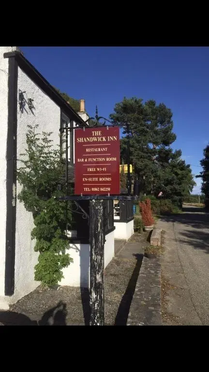 a red sign on the side of a building at The Shandwick Inn in Tain