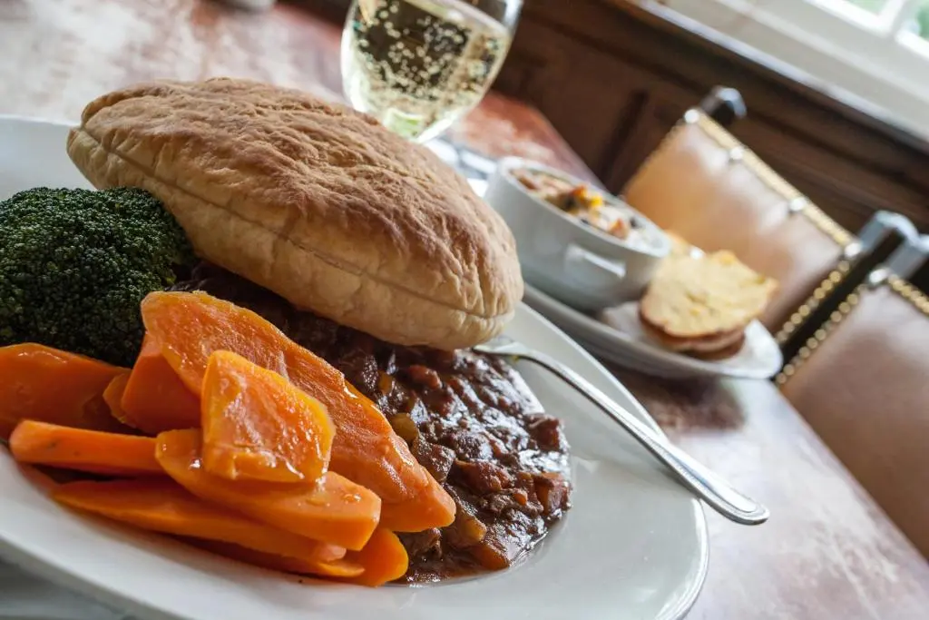a plate of food with a sandwich and vegetables at The Shandwick Inn in Tain