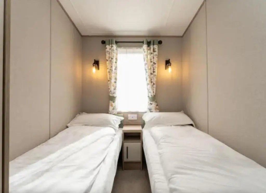 two beds in a small room with a window at ScottishHighlands in Boat of Garten