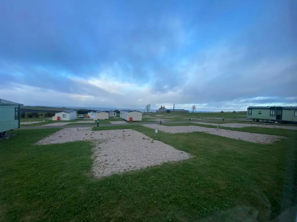 an aerial view of a field with buildings and grass at No 56 Headiton Caravan Park in Banff