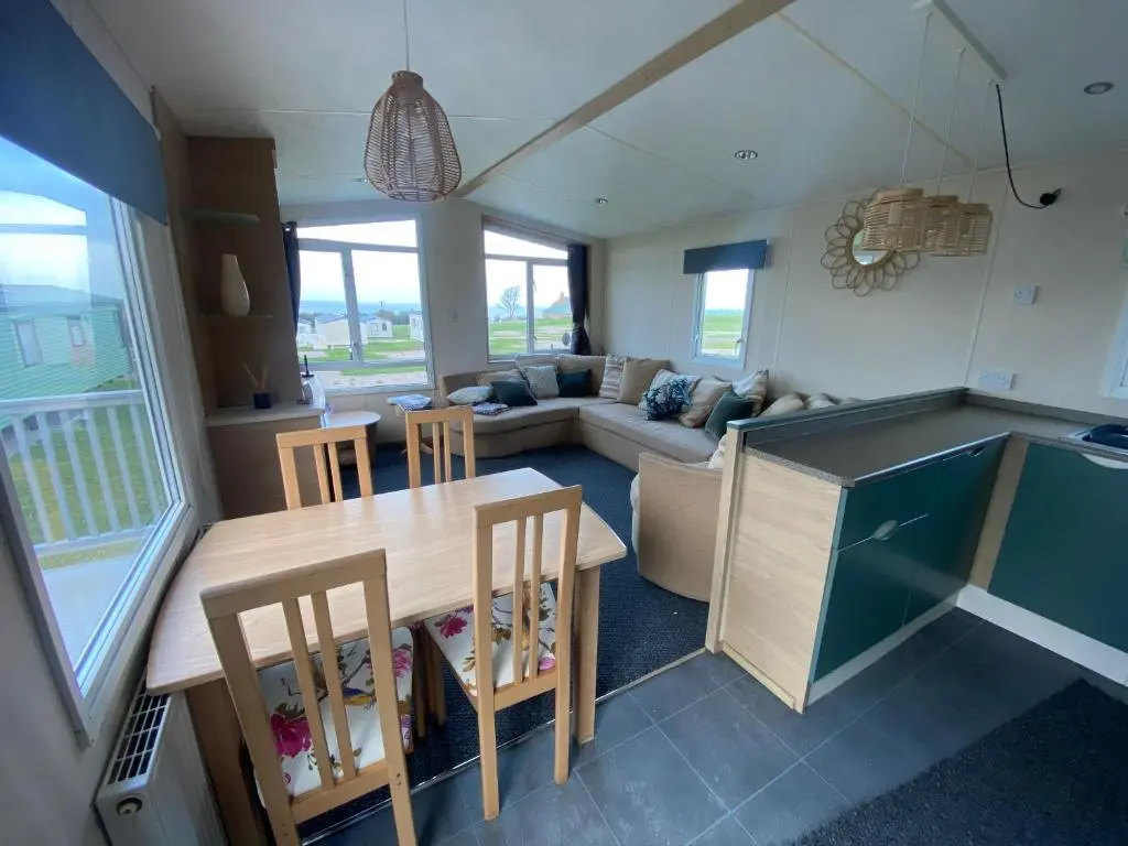 a kitchen and living room with a table and chairs at No 56 Headiton Caravan Park in Banff