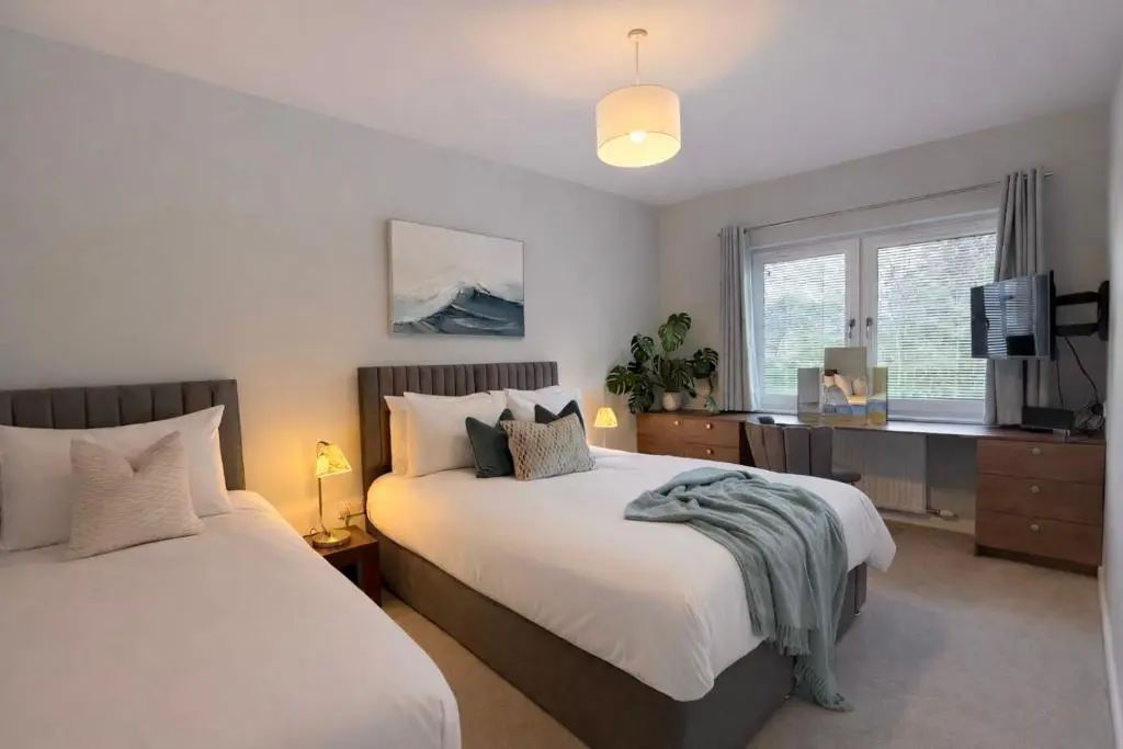 a bedroom with two beds and a television in it at Ness Garden in Inverness