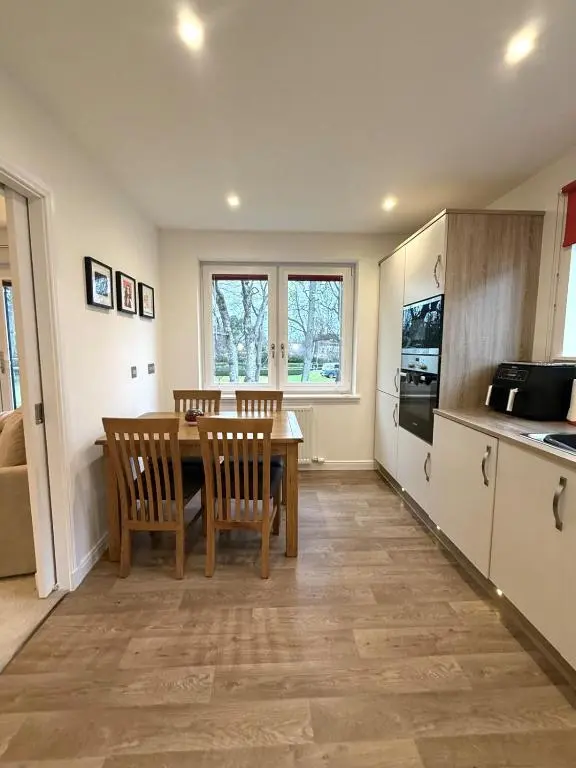 a kitchen with a table and chairs in a kitchen at Ness Garden in Inverness