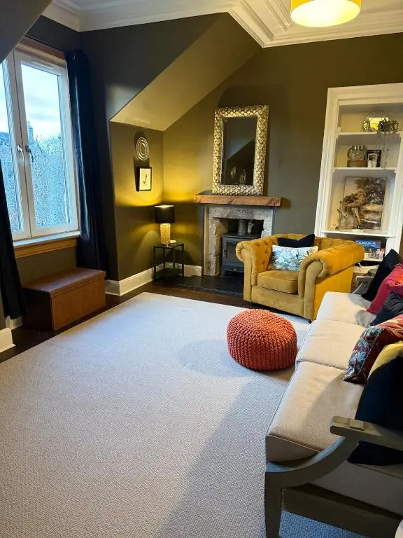 a living room with a couch and a fireplace at The Yellow Door in Inverness